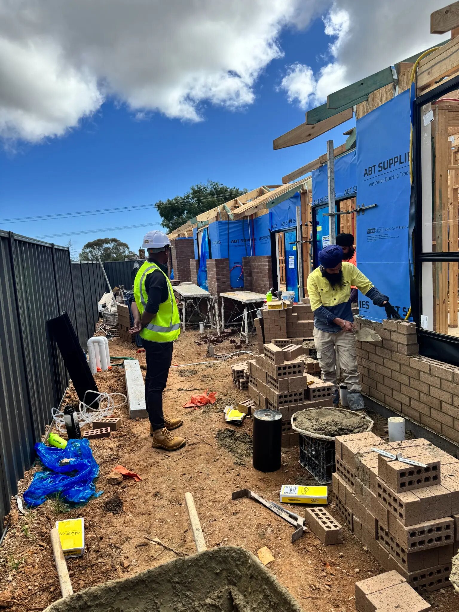 Imon Hussain supervising bricklayers on an active residential construction site
