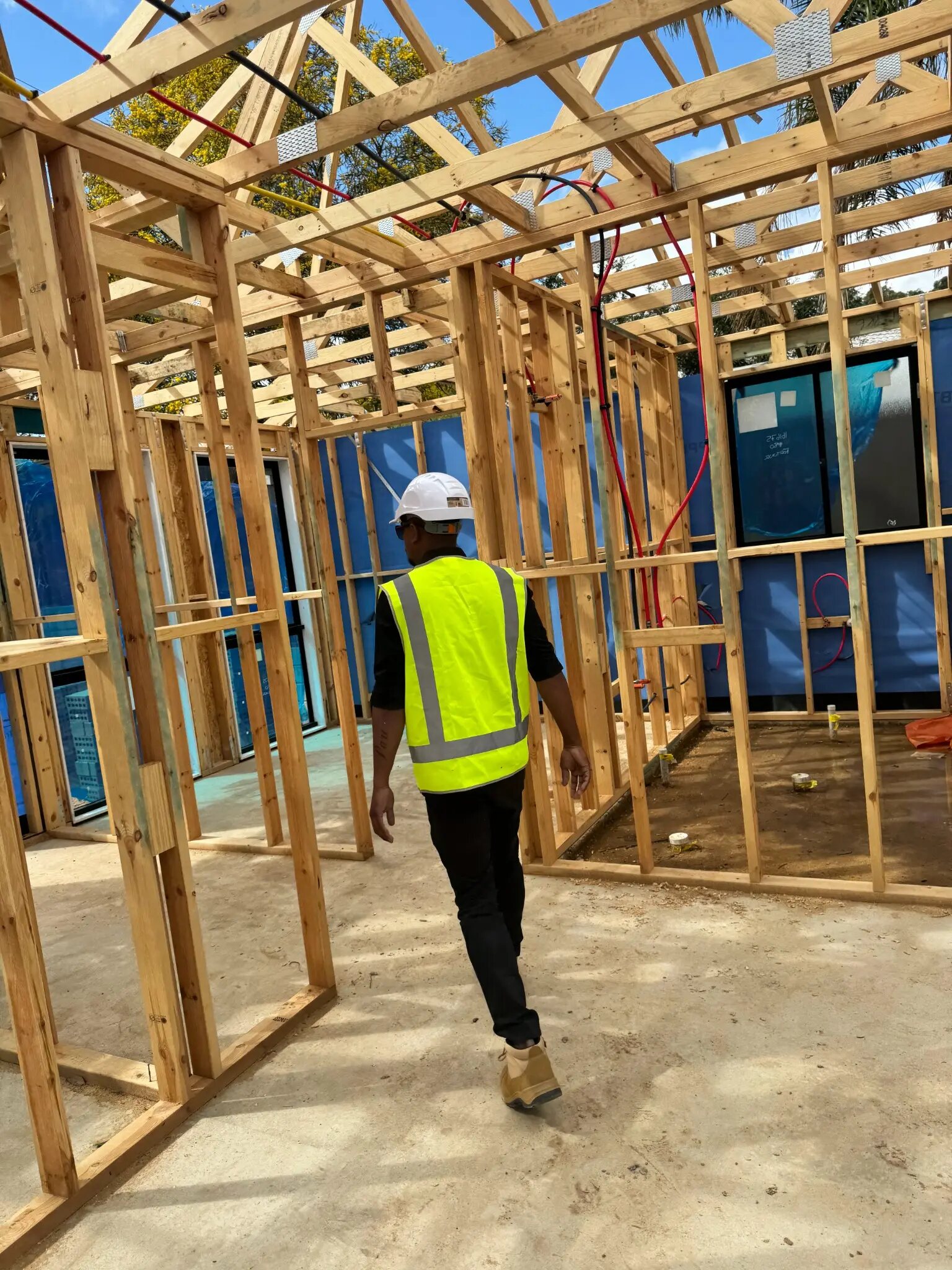 Maverick Builds walking through a timber-framed home during construction
