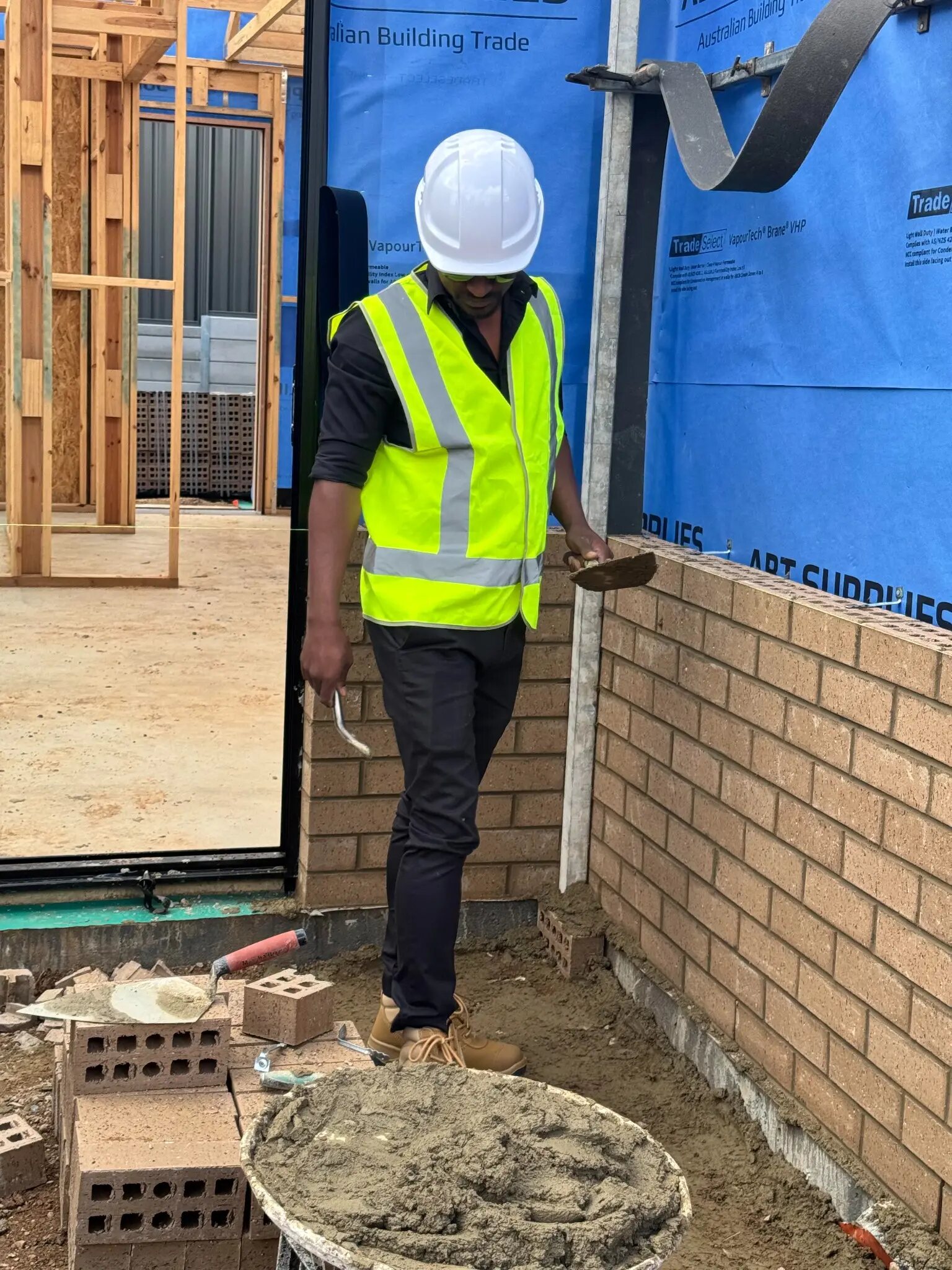 Imon Hussain checking brickwork detail during residential construction