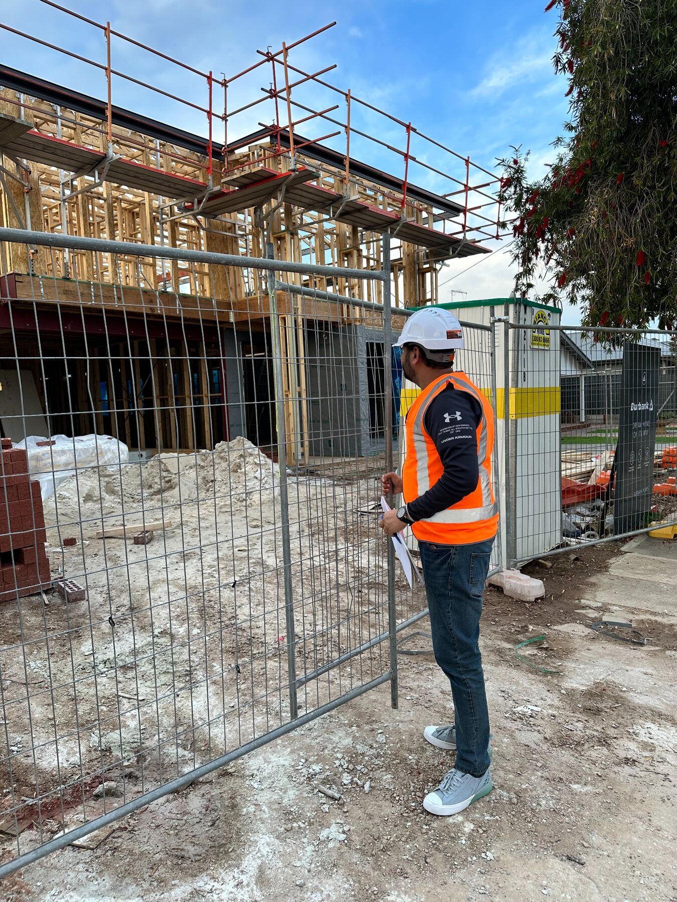 Imon Hussain reviewing framing progress from outside an active residential construction site