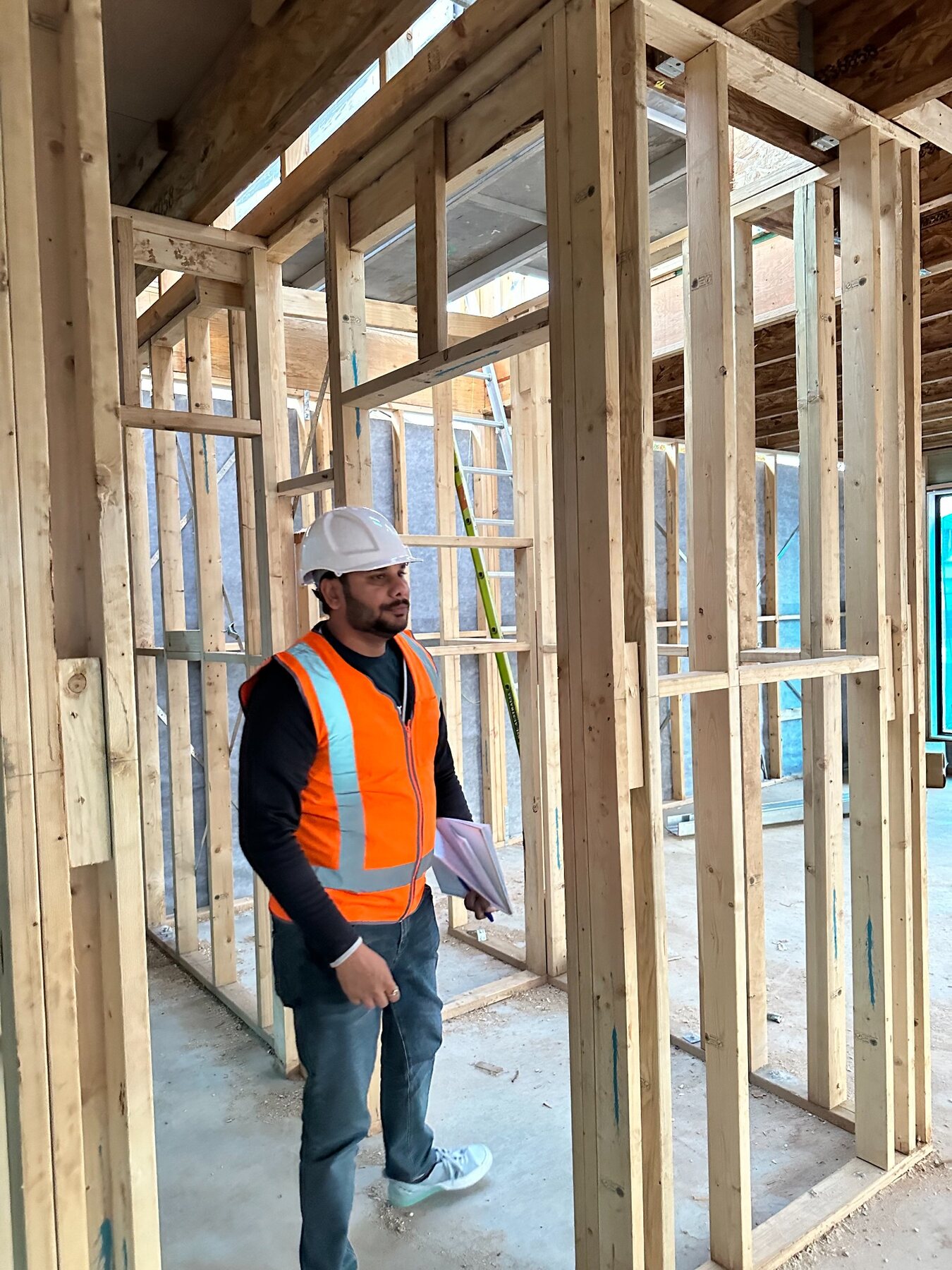 Imon Hussain walking through internal timber framing during construction
