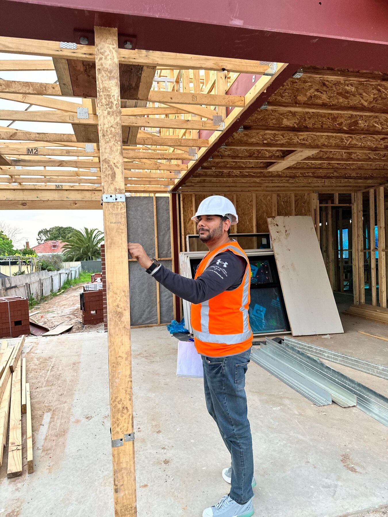 Imon Hussain checking a timber post and frame connection during construction