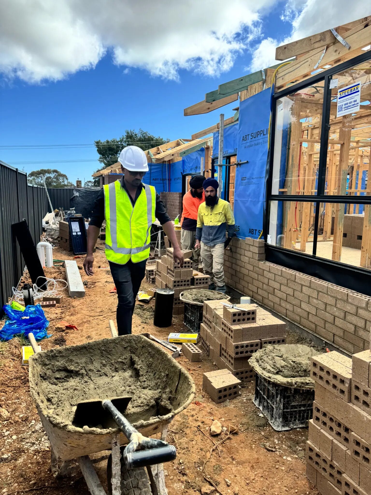 Imon Hussain walking through active brickwork with the site team