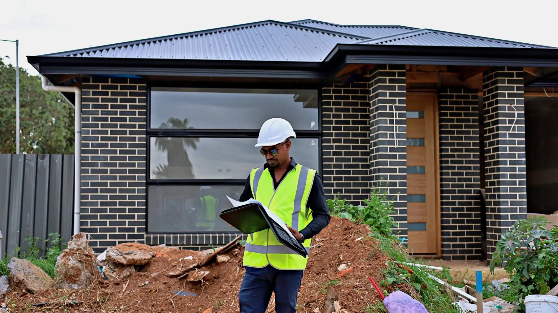 Imon Hussain, Registered Building Supervisor at Maverick Builds, reviewing plans on an Adelaide residential project