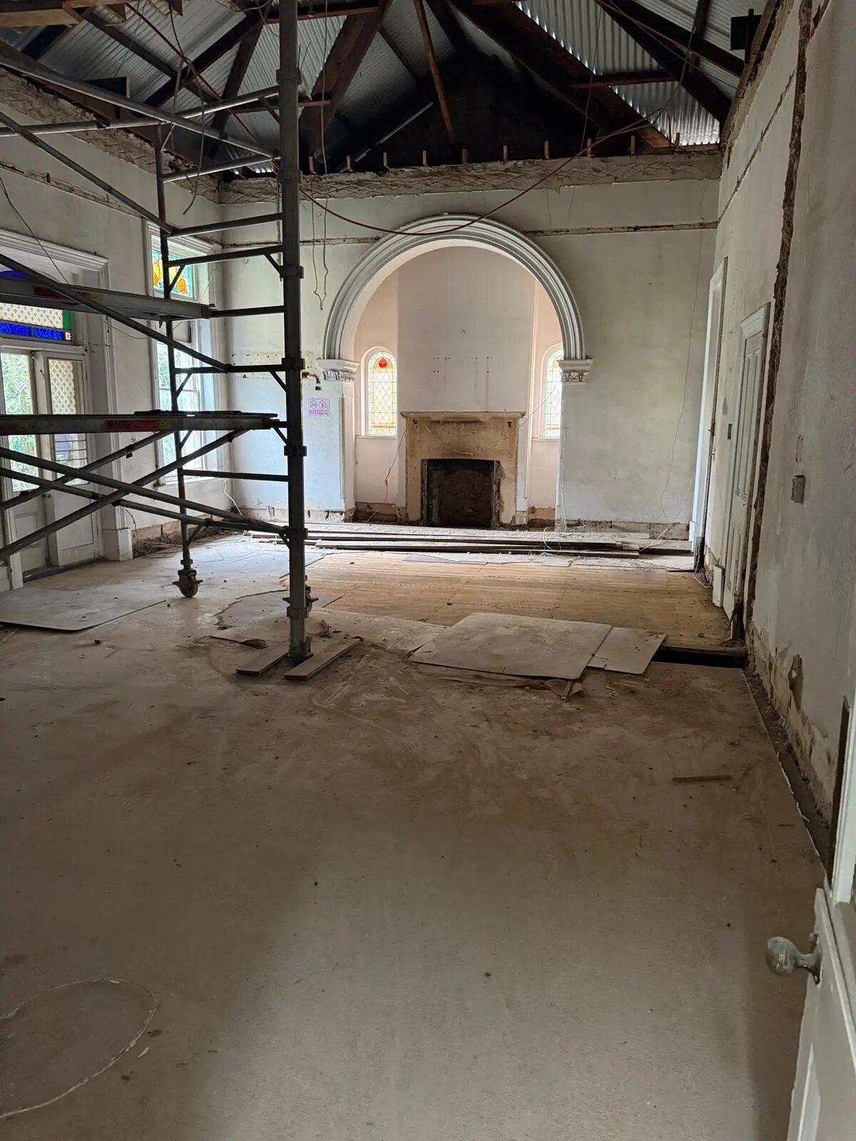 Character interior with arched opening and fireplace during heritage renovation